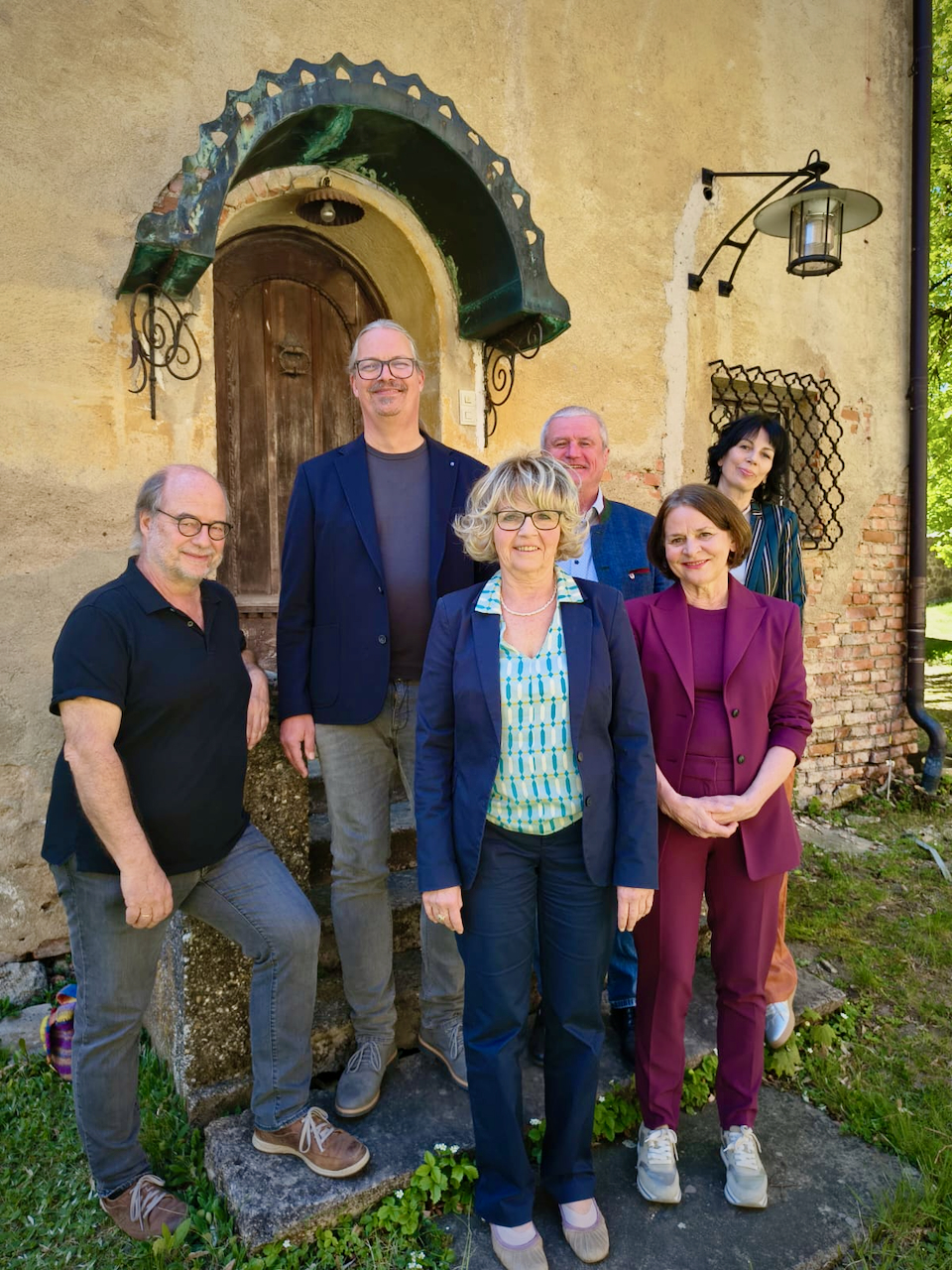 Kreistagsfraktion 2020 bis 2026 der Grünen im Passauer Land. Sechs Personen stehen vor einem Haus und lächeln in die Kamera.