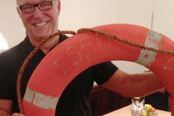 Der Wirt Peter Wolf mit einem Rettungsring, den er zur Einweihung nach der Sanierung von Alexander Maier geschenkt bekommen hatte, als Symbol, dass sich die Hochwasserkatastrophe nicht mehr wiederholen solle.