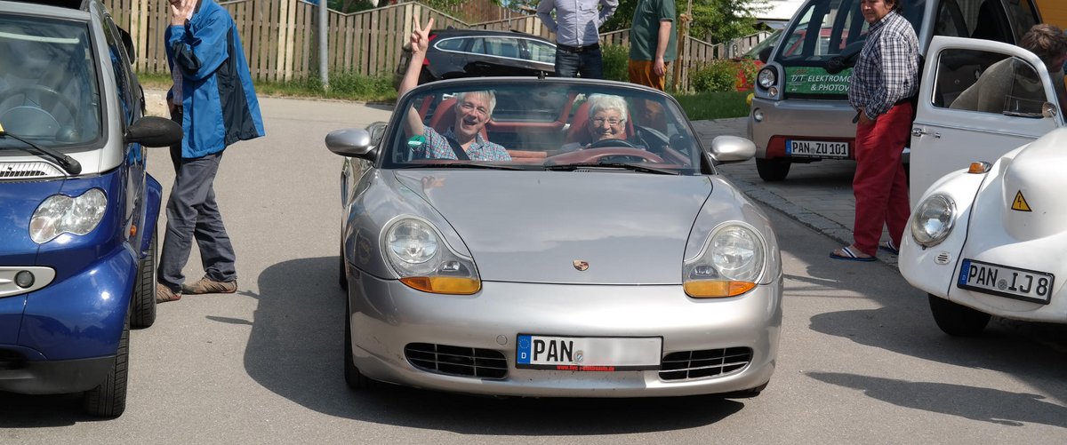 Flotte Ernergiewende: Halo Saibold (Kreisrätin) fährt Dirk Wildt (Kreisvorsitzender) im umgebauten Elektro-Porsche durch das Sonnendorf Schönau.