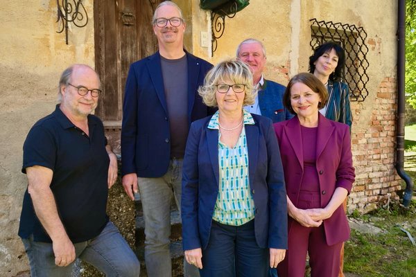 Kreistagsfraktion 2020 bis 2026 der Grünen im Passauer Land. Sechs Personen stehen vor einem Haus und lächeln in die Kamera.