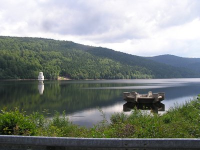 Verkraftet nur zwei trockene Jahre: die Trinkwassertalsperre Frauenau. Hier mit Entnahmeturm und Überlauf (vom Damm gesehen) | Foto: CC BY-SA 3.0, https://commons.wikimedia.org/wiki/User:MdE